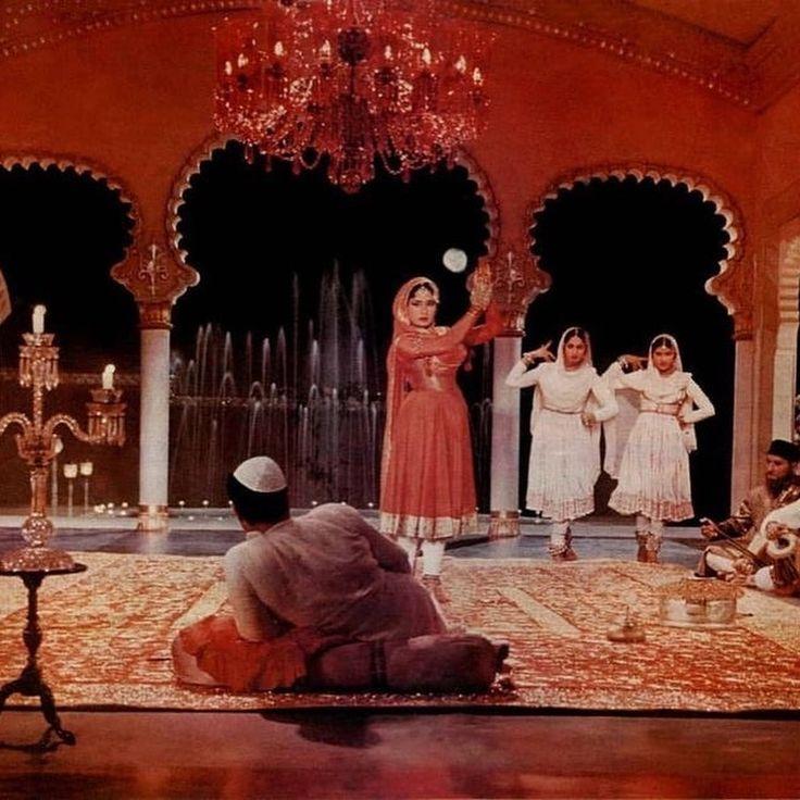This may contain: a group of people standing on top of a rug in front of a fountain and chandelier