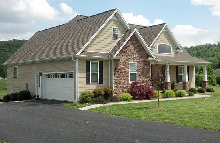 Left exterior view showing the side-entry garage complemented with an asphalt driveway.