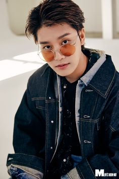 This contains an image of: NCT TAEIL wearing glass and his also putting on a jean jacket.  