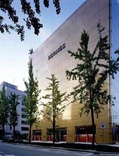 This contain an  image of office building with trees in front of it