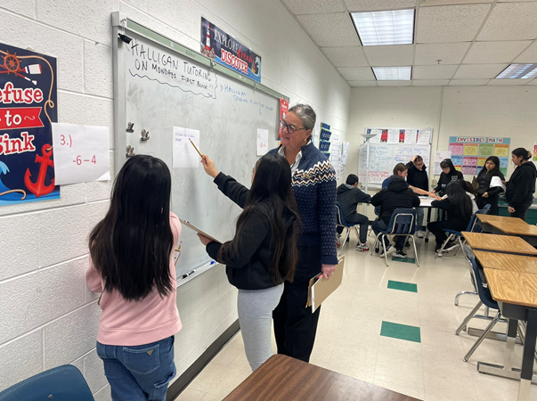 Dr. Reid talking with students at Poe Middle School about a math lesson.