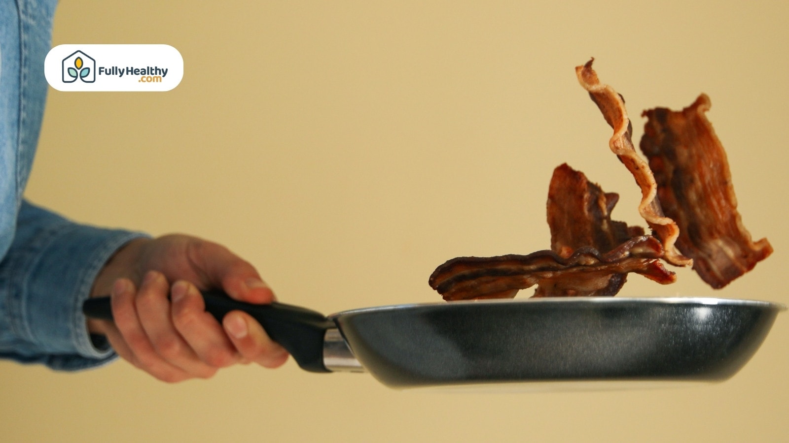 Crispy bacon slices mid-air above frying pan