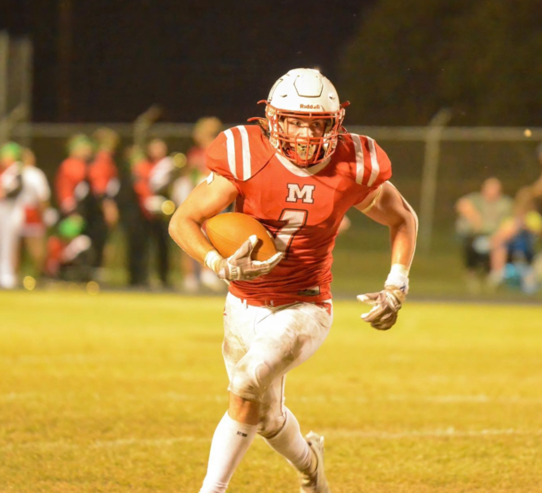 A football player running with a football

Description automatically generated