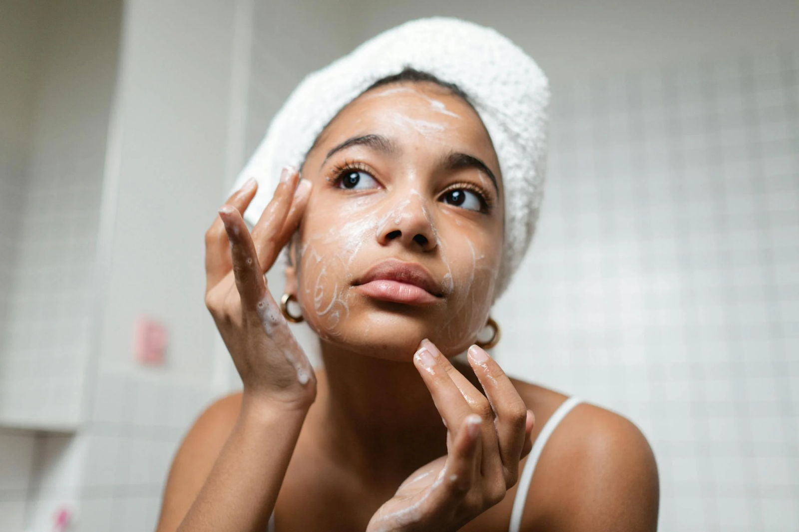 A woman cleansing her face with soap 