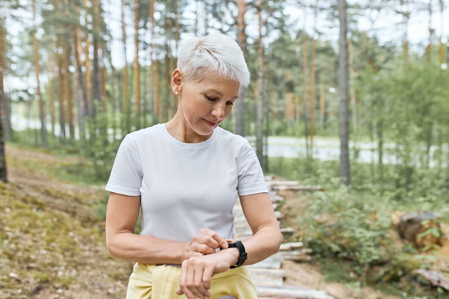 Serious woman checking her smartwatch for GPS tracking and location updates