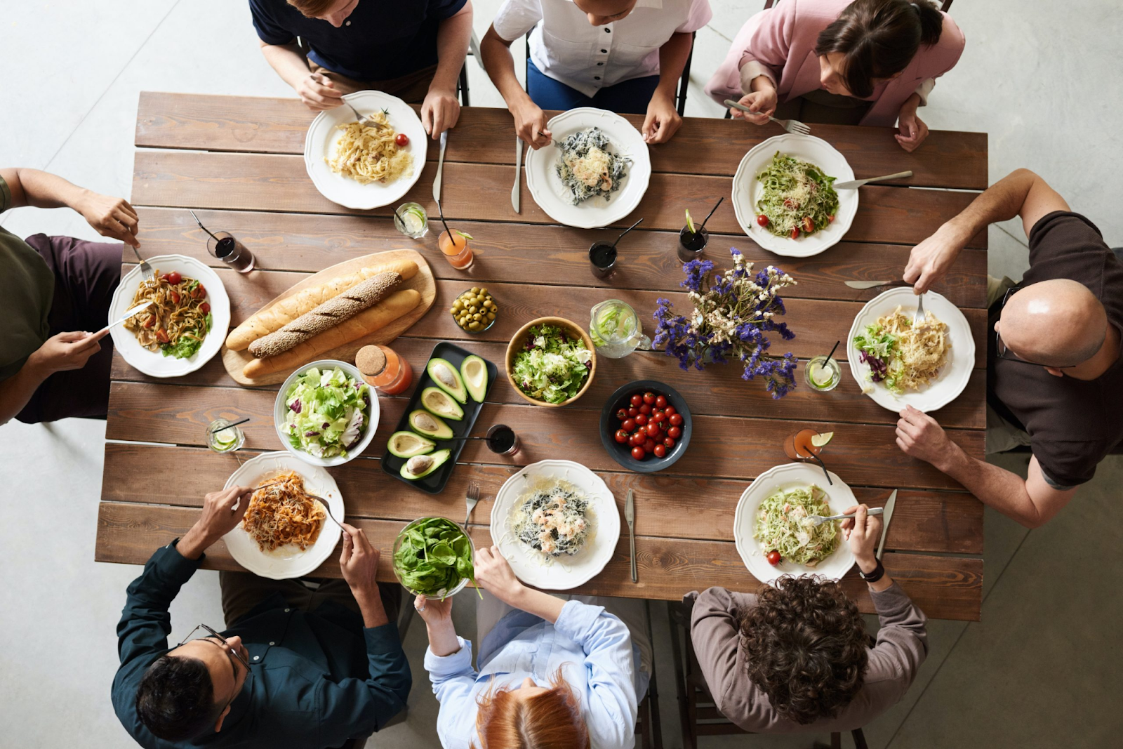 A group of employees having a healthy lunch during office lunch break that is a part of wellness tips for employees.