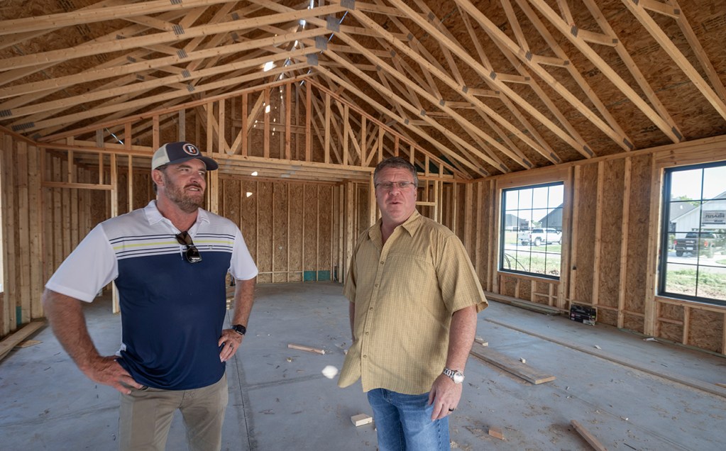 Two men inside a house being built