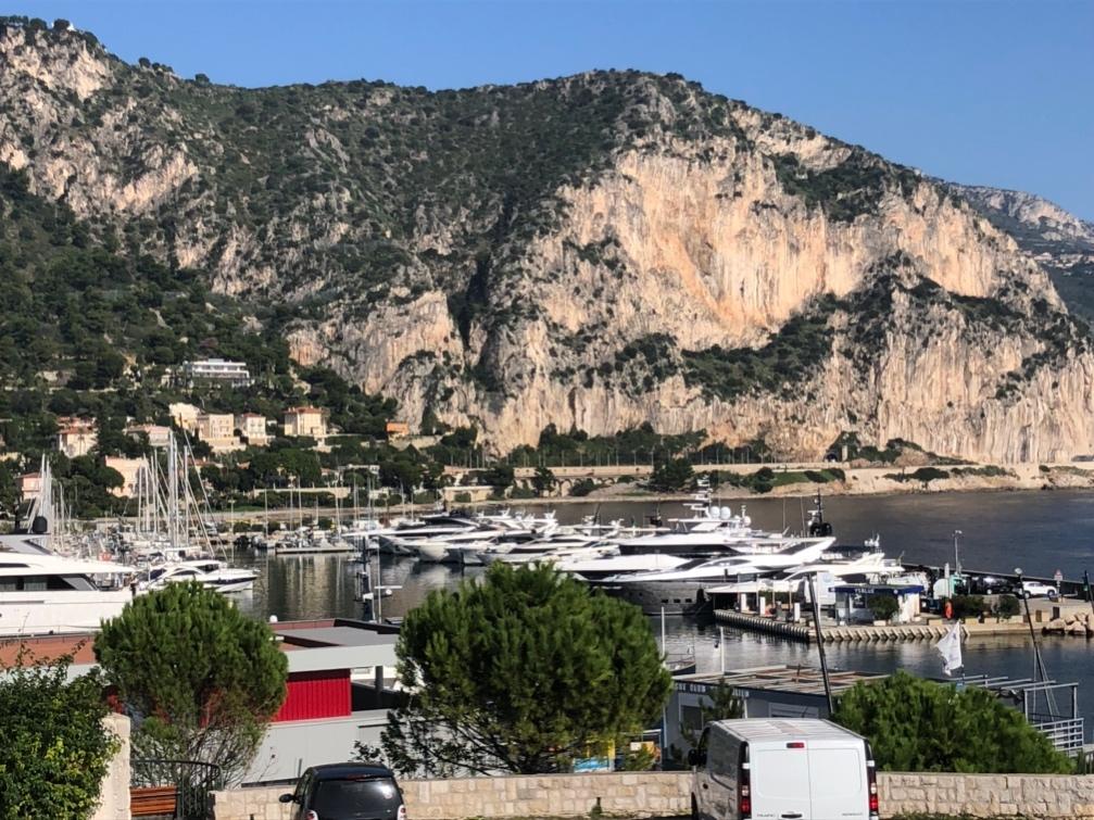 A body of water with boats and a mountain in the background

Description automatically generated