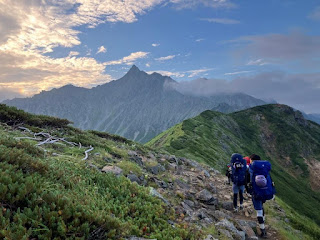 山の上を歩いている男

自動的に生成された説明