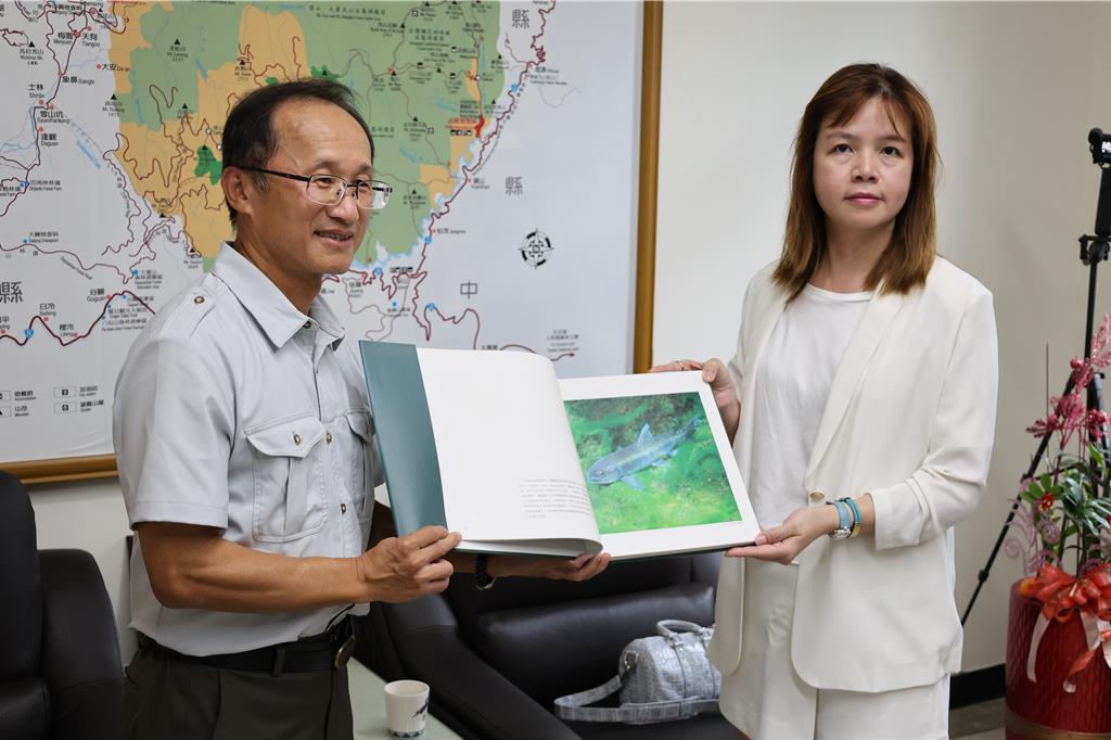 聖石企業董事長邱嬿妤(右)親自南下雪霸國家公園管理處拜訪處長林文和,由林文和贈送國寶魚專冊等書(謝明俊攝)