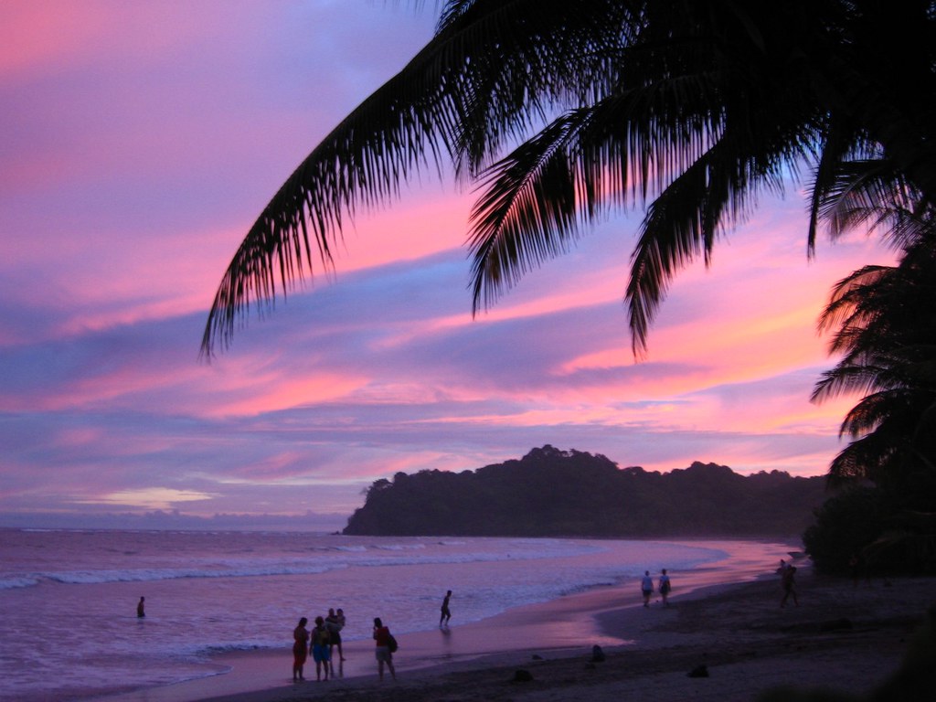 Clear water and brown sand at the border as its sunset time sky turn into vibrant colors