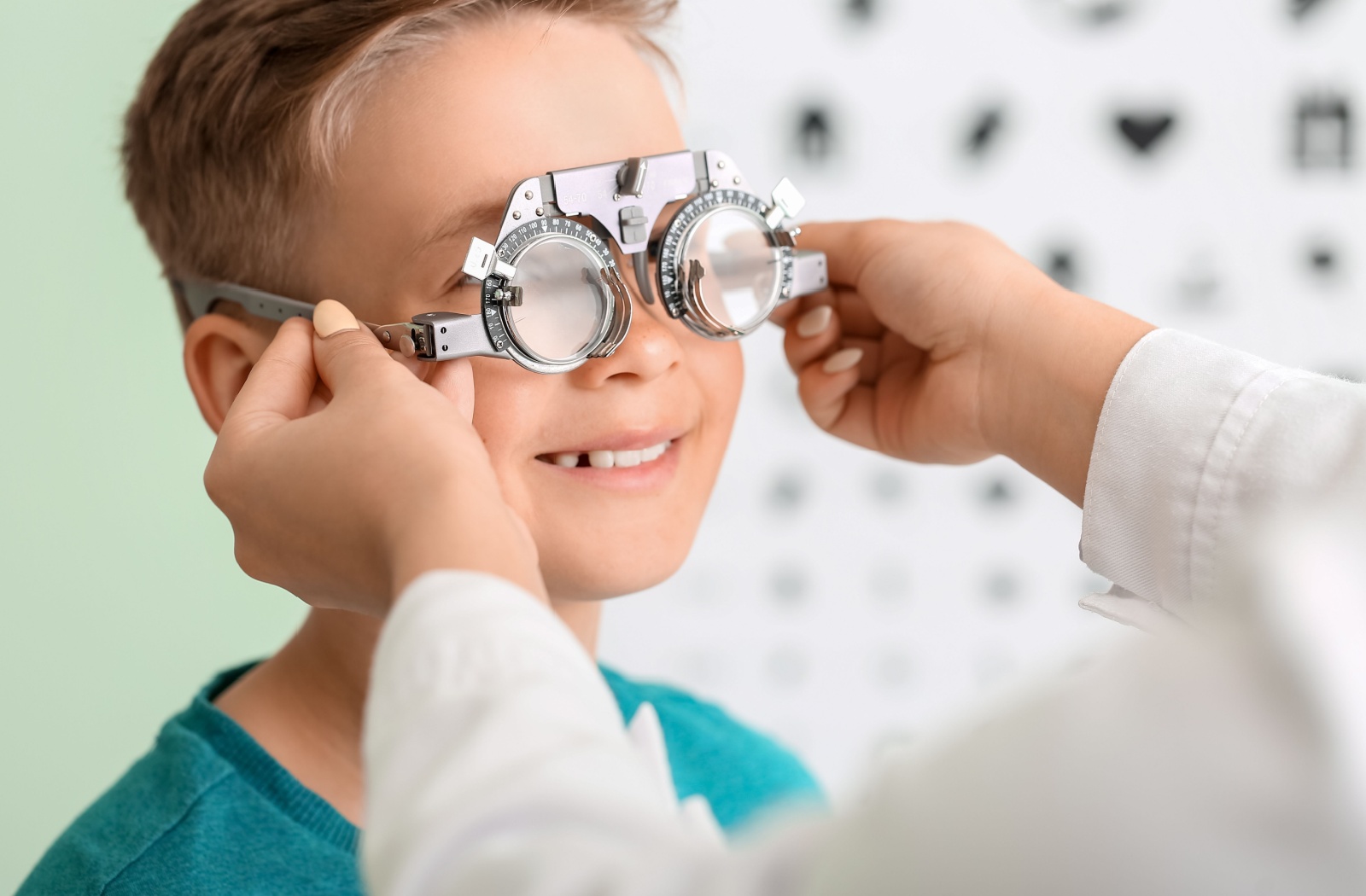 A child gets their eyes checked for glasses by an optometrist.
