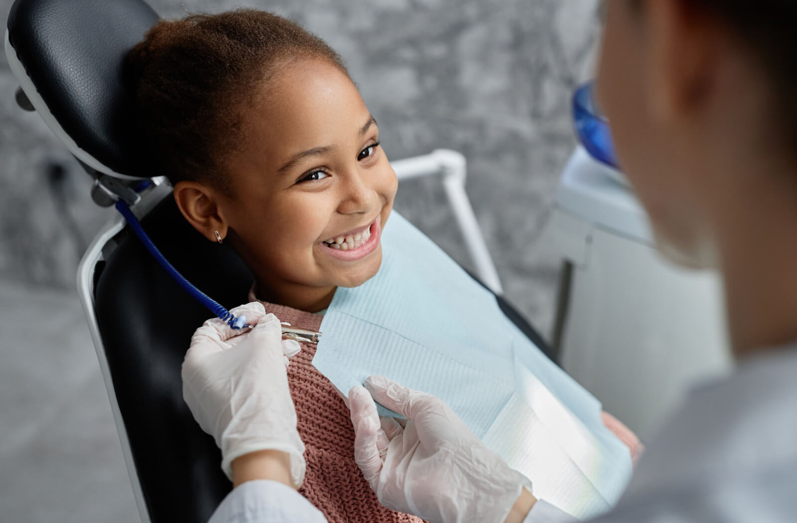 A little girl smiling at the dentist while preparing for Solea laser dentistry treatment.