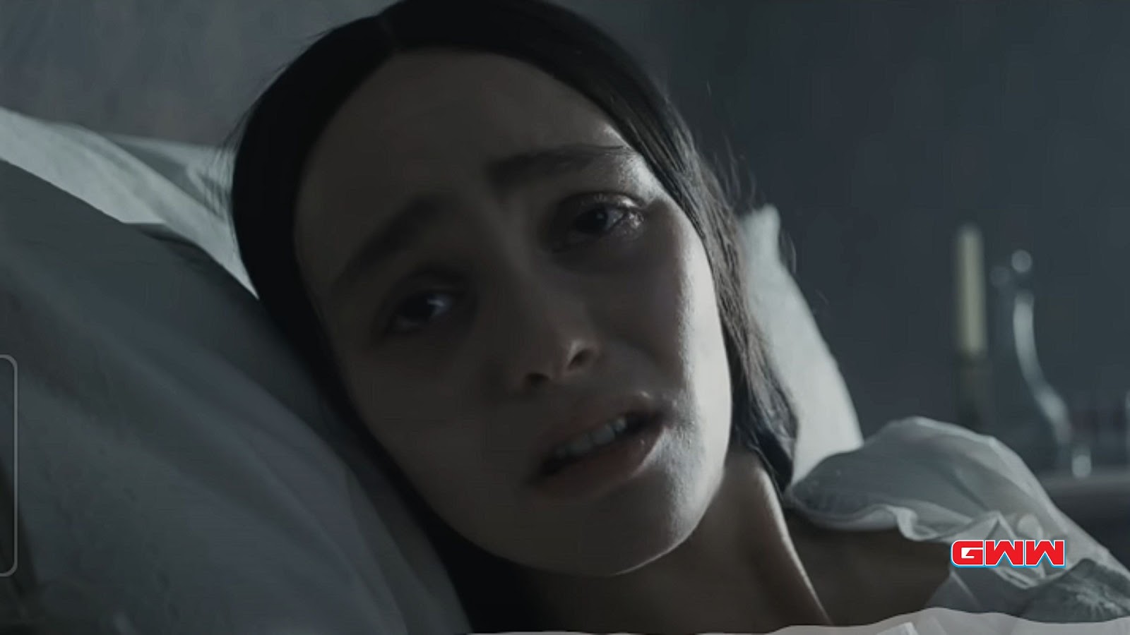 Pale, concerned Anna Harding lying in bed from Nosferatu 2024 film.