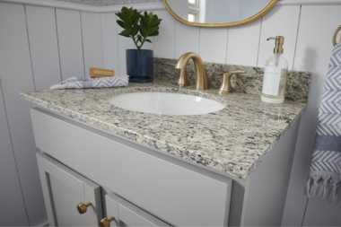 how to select the perfect countertops for your bathroom remodel granite countertop with gold finished faucet and circular mirror custom built michigan