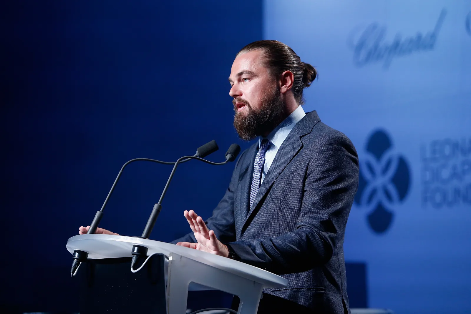 Leonardo DiCaprio in the mid-2010s, rocking cute slicked-back hair with a bun atop his head