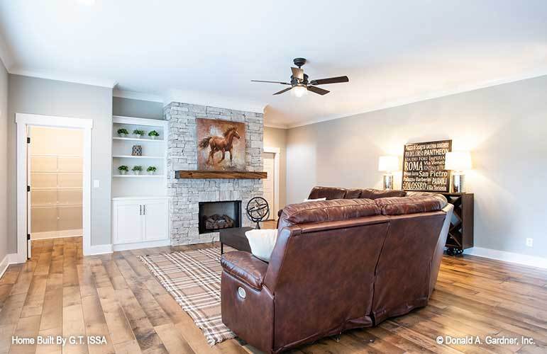 The recreation room includes a stone fireplace and white built-in cabinet.