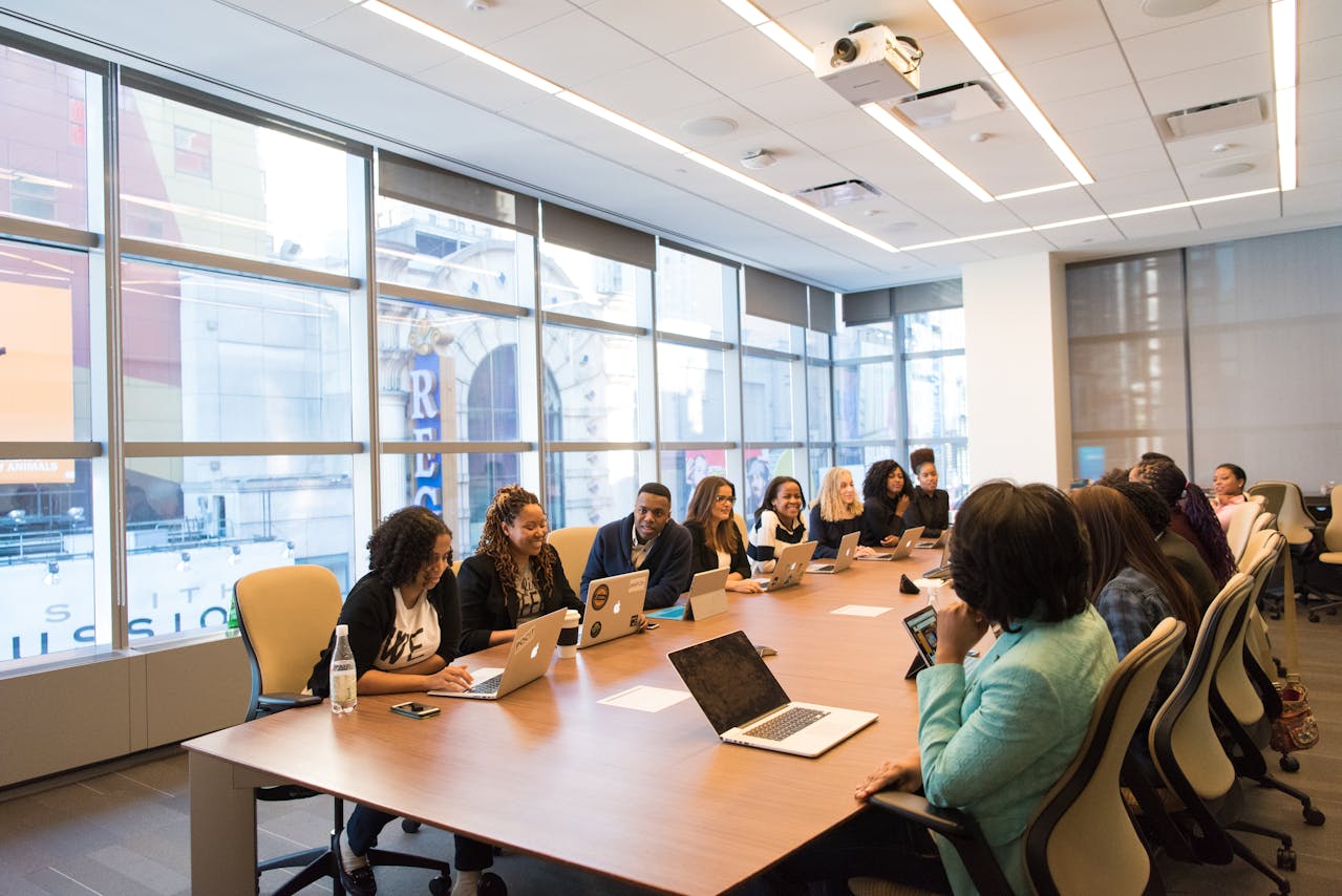 Diverse group of professionals engaged in a business meeting in a well-lit conference room, embodying the essence of how to run successful meetings