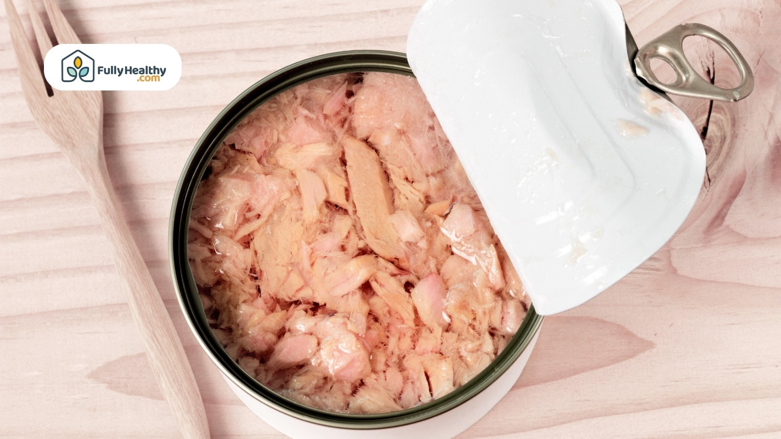 Opened canned tuna on a wood table