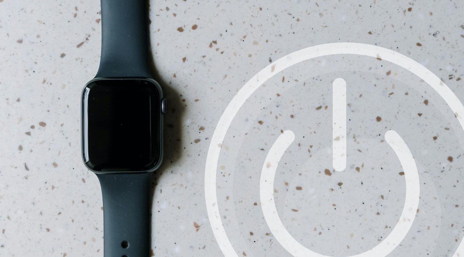 A black Apple Watch with black band placed on a surface with a superimposed power icon in the bottom-right corner