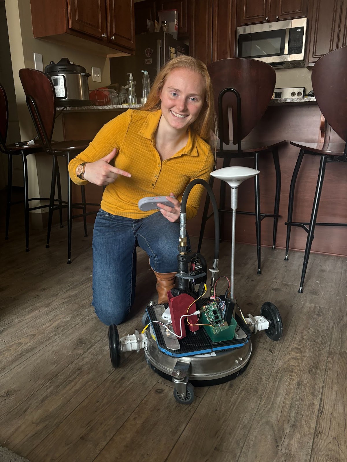 Elyse poses with a prototype of the Robot for her venture which started as a "roomba for driveways."