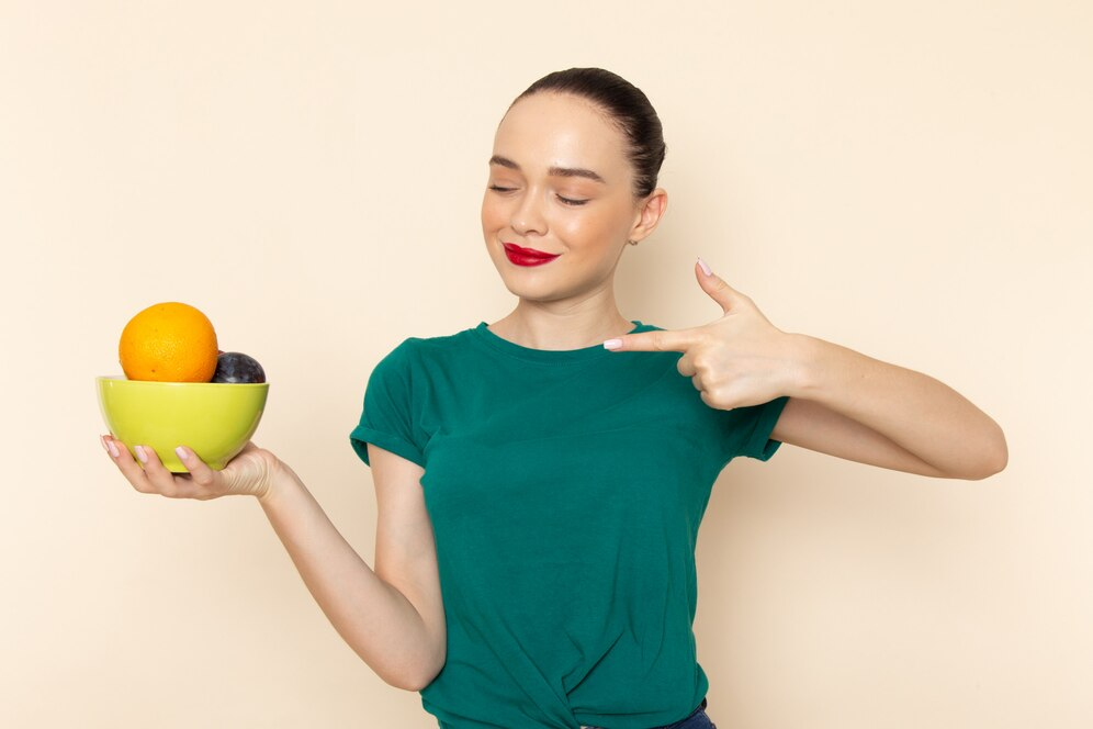 A girl holding a bowl of fruits in her hand