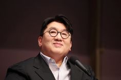 A picture of Chairman Bang Si Hyuk on black suit and white shirt 