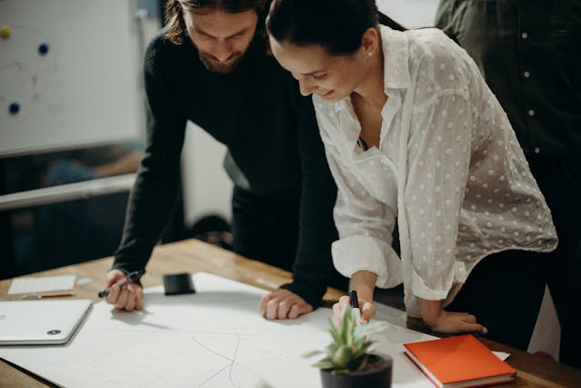 Two colleagues collaborating on a project, sharing ideas and working together at a table