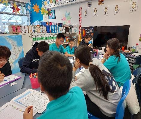 A group of people sitting at a table in a classroom AI-generated content may be incorrect.