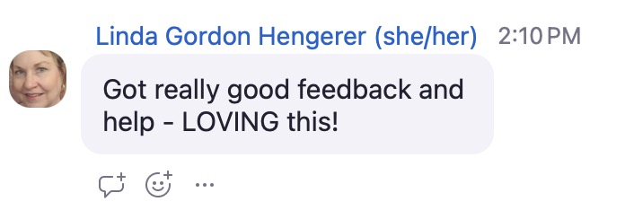 A screenshot of a chat message from Linda Gordon Hengerer (she/her), timestamped at 2:10 PM. The message reads: “Got really good feedback and help – LOVING this!” in a rounded light purple speech bubble. Her profile picture is a close-up photo of her smiling face. Below the message are options for emoji reactions and additional message actions, represented by icons.
