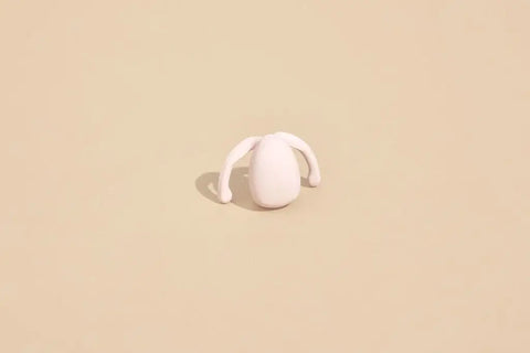 Eva Hands-Free vibrator sits propped upright on tan background