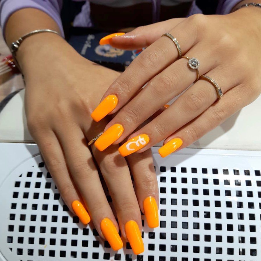 Close up of nails with glittery orange nails having Neon Orange for the Bold