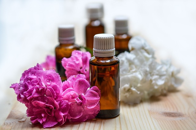 Bottle of essential oils and fresh flowers.