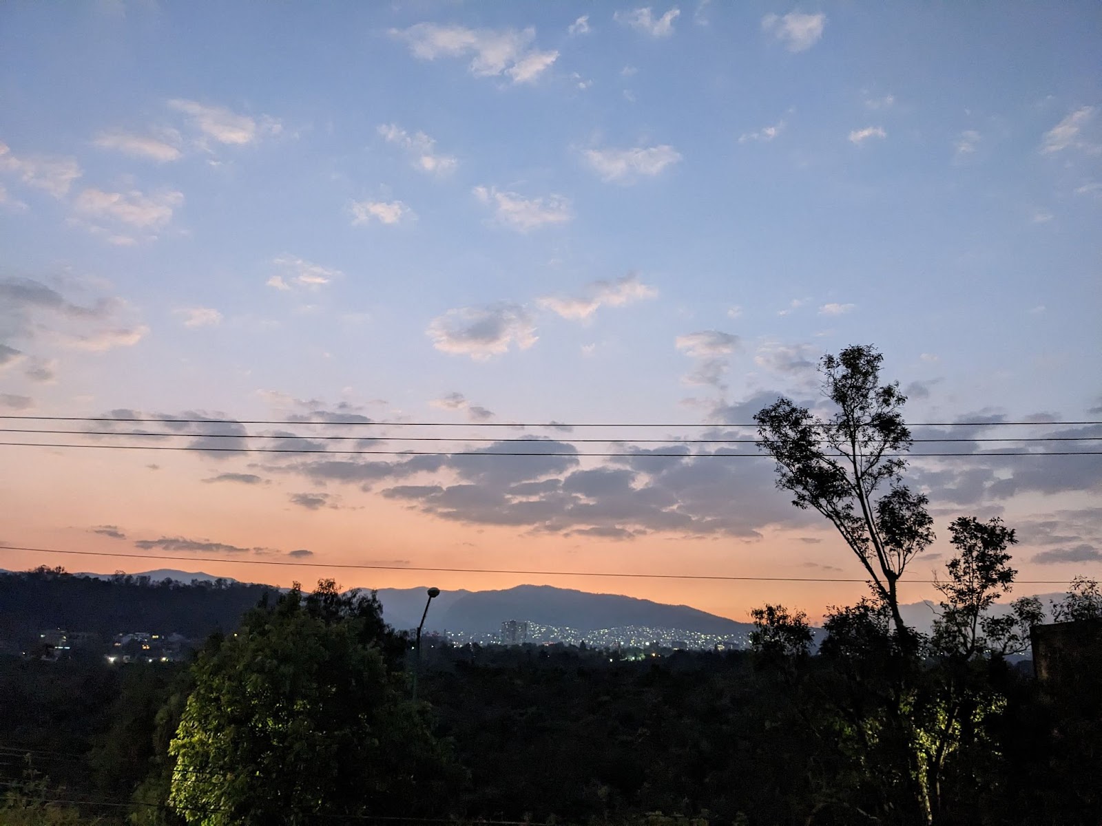 the dusk sky overlooking the mountains and cityscape of mexico city, from Camino verde the gay cruising and hookup spot for gay bisexul and curious males in mexico and mexico city