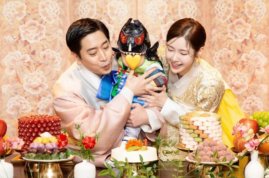 This contains an image of Shinhwa's Eric his wife Na Hye Mi and child together celebrating his birthday