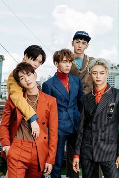 This contains an image of  SHINee's 
 group of young men standing next to each other in front of a cityscape