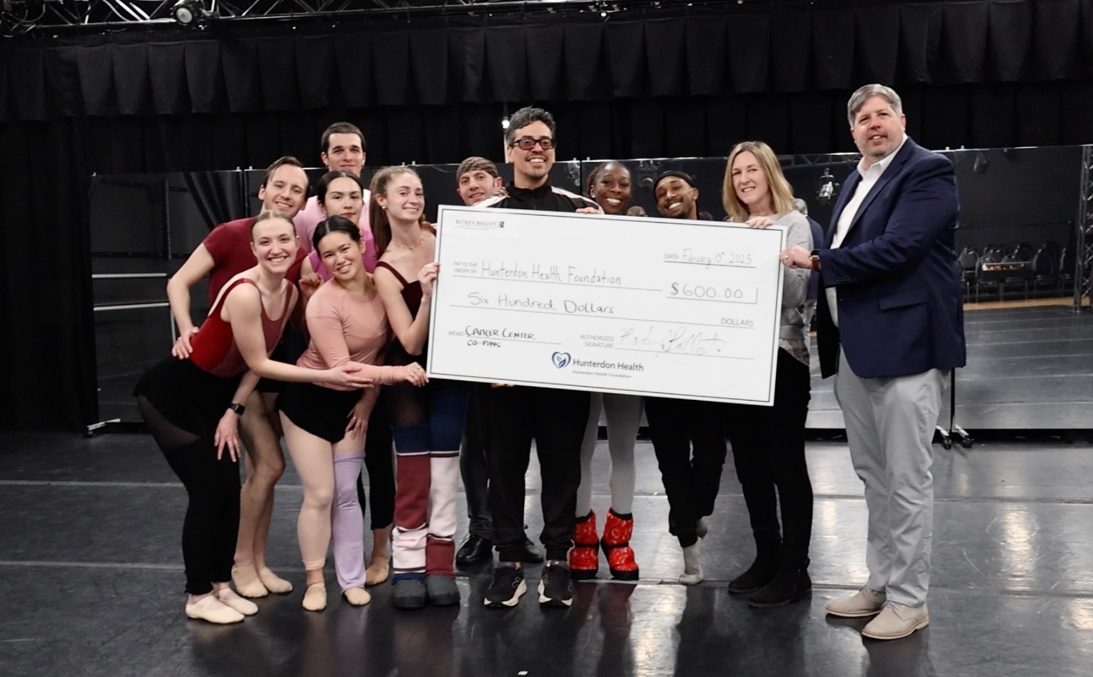 Members of Roxey Ballet pose with large check donation