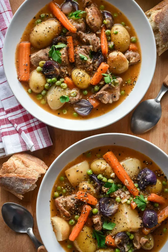 Two bowls of soup with vegetables and meat

Description automatically generated