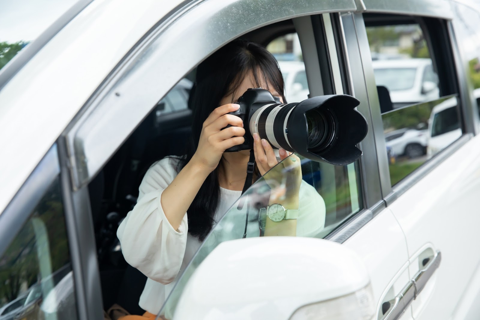 車から写真を撮る女性