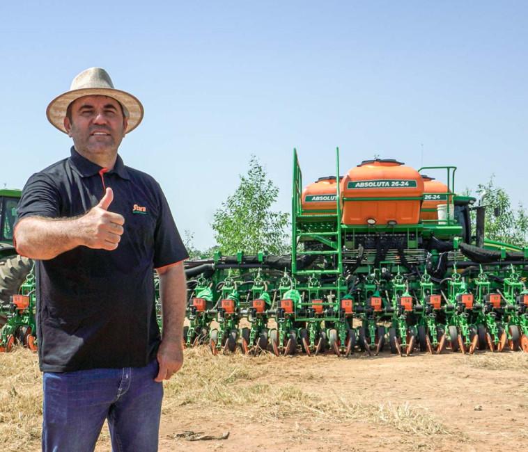 Produtor rural fazendo sinal de positivo em frente a uma plantadeira Stara Absoluta comprada com financiamento agrícola da Stara Financeira