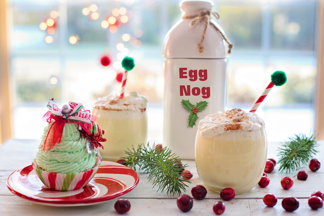 Free Charming Christmas display with eggnog and festive cupcake on a table, perfect for the holiday season. 