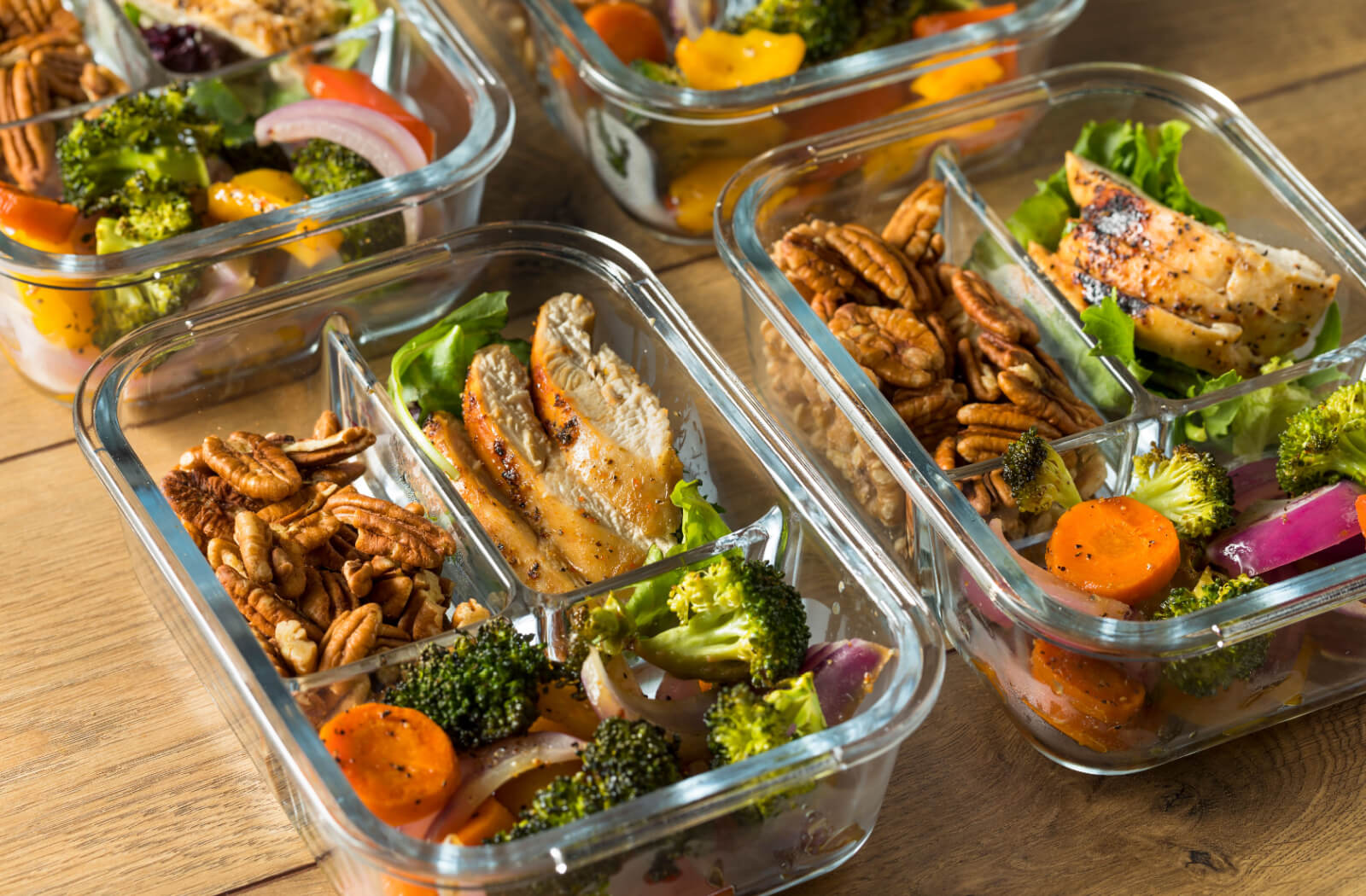 A close-up image of several pre-prepared keto-friendly meals in glass containers for a senior.