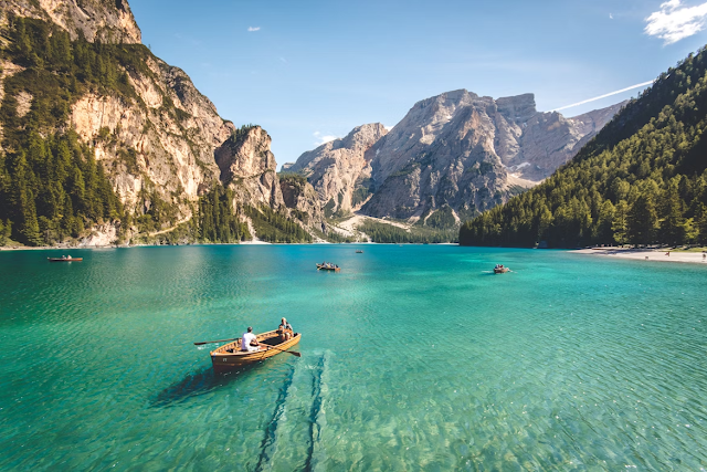 people kayaking down a beautiful river surrounded by mountains