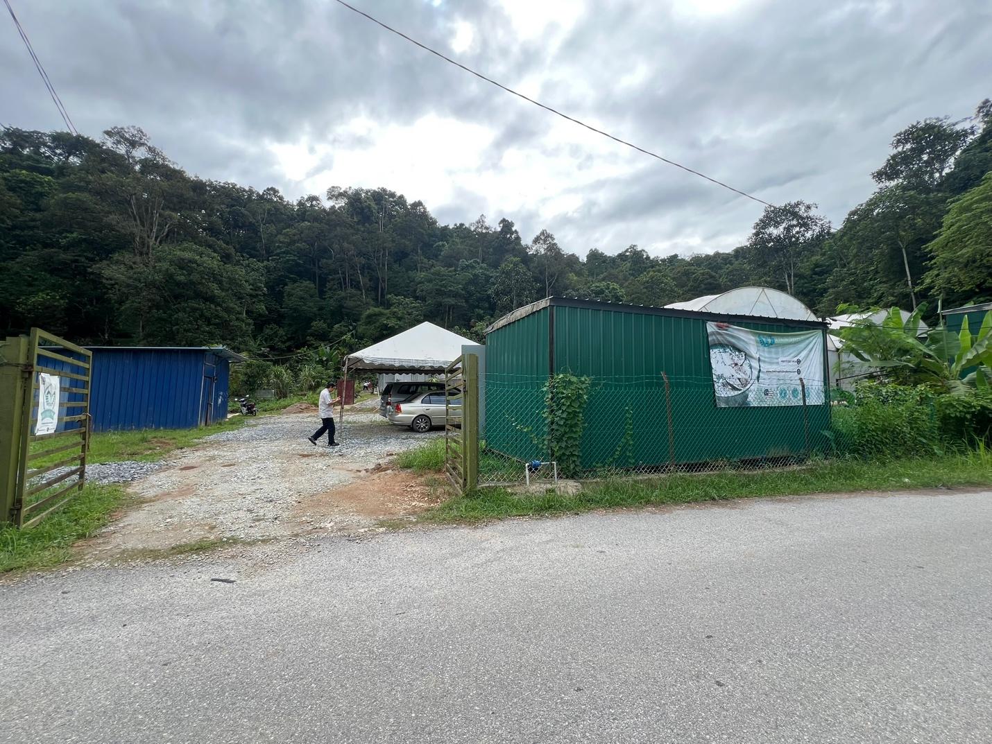 A green metal building next to a road

Description automatically generated