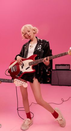 This contain BLACKPINK's Rosé on "APT  with blonde hair is holding a guitar and posing for a photo in front of a pink background