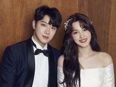 This containFTISLAND's Choi Minhwan and his wife  Yulhee in formal wear posing for the camera