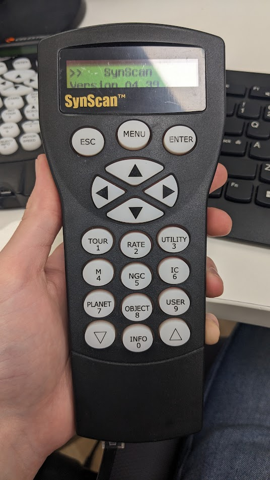 An image of the Synscan Hand Controller layout. Image shows display, 3 settings buttons underneath display, 4 navigational control buttons in the middle, and a numpad with 2 scroll buttons underneath.