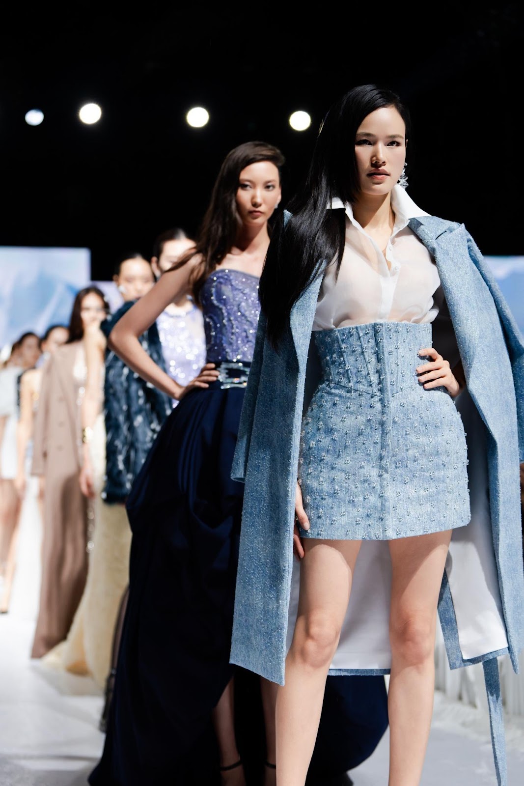 A group of women on a runway

Description automatically generated