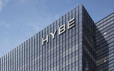 This  contain an image of  the hybe logo is on top of a building