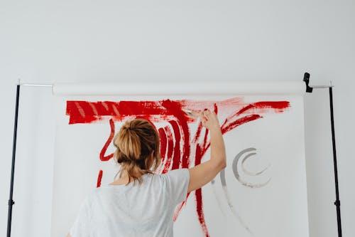 Free Back View of a Woman Painting on White Textile Stock Photo